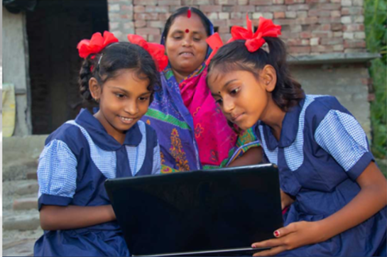 Girls using laptop in rural home